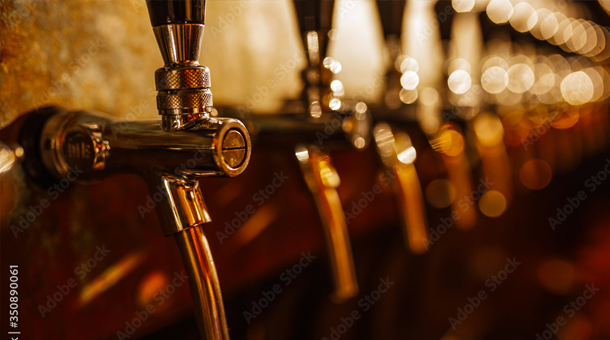 Shiny beer taps in a dim bar.